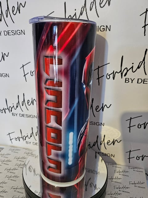Red and blue insulated tumbler with metallic text design, displayed on white base with branded background
