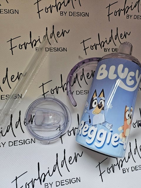 Two clear cosmetic containers with a blue Bluey and Bingo character bottle on Forbidden by Design branded background