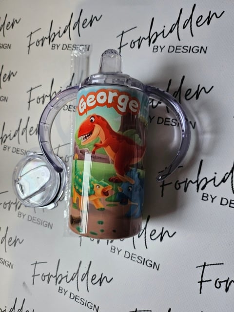 Clear plastic sippy cup with George dinosaur character design on a Forbidden By Design branded background