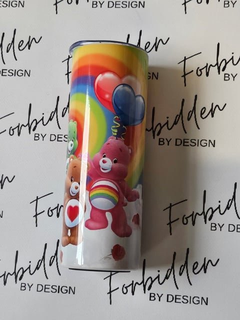 Colorful cylindrical cup featuring Care Bears characters with rainbow gradient background and repeating Forbidden By Design watermark